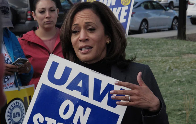 Kamala Harris talks to striking workers after walking a picket line with UAW member